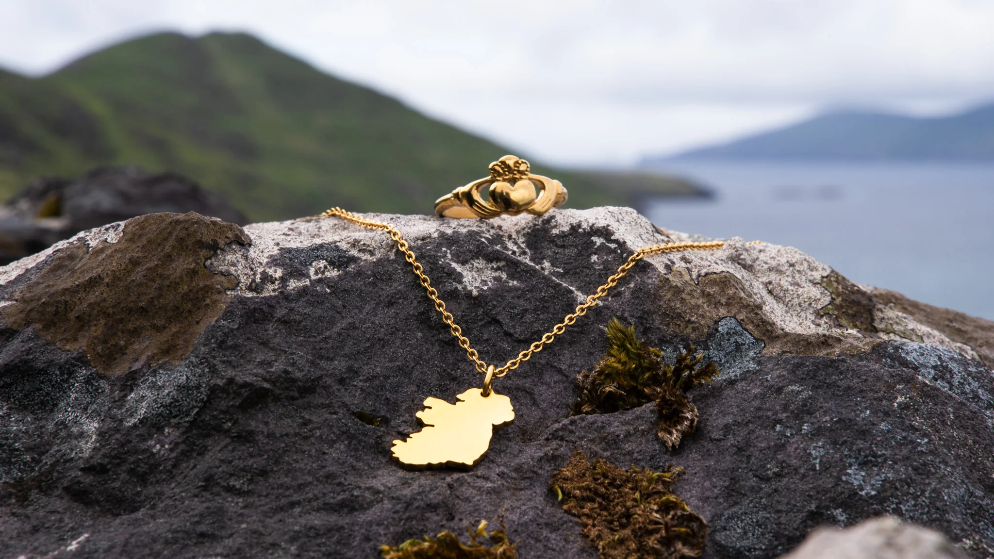 Fíor Jewellery gold necklace on rock with Irish landscape background – Shopify jewellery brand case study